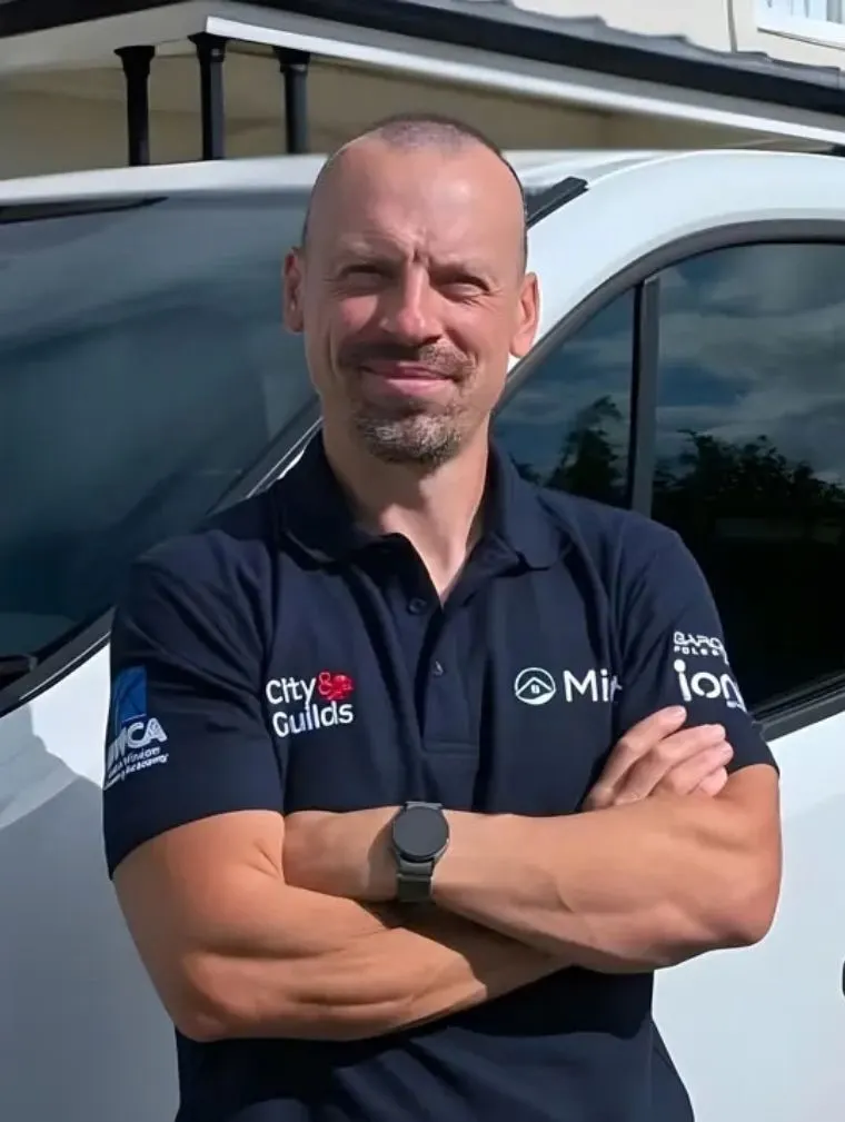 Tom Buxton, founder of Mint Exterior Property Services, standing beside the Mint van